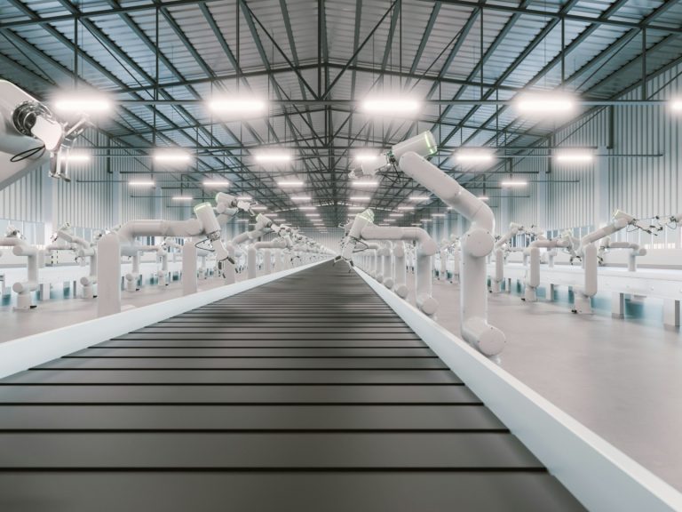 A modern industrial facility with robotic arms along a conveyor belt.